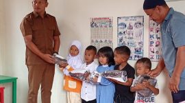 Ket. Foto : Pj Geuchik Andi Iskandar Rizza melalui Sekretaris Desa (Sekdes) Sarizal dan Ketua Tuha Peut Gampong Tgk.Mustafa menyerahkan Baju Seragam Polisi kepada Anak PAUD Bunda Cinta Raja (09/09/2025) 