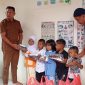 Ket. Foto : Pj Geuchik Andi Iskandar Rizza melalui Sekretaris Desa (Sekdes) Sarizal dan Ketua Tuha Peut Gampong Tgk.Mustafa menyerahkan Baju Seragam Polisi kepada Anak PAUD Bunda Cinta Raja (09/09/2025) 