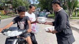 Ket. Foto : Ketua SAMMI Kota Langsa, Muhammad Reza, SH, Berbagi Jum'at Berkah, Kepada Masyarakat, yang melintas di depan Kantor Pegadaian Syariah Kota Langsa, Jum'at pagi (7 November 2025).