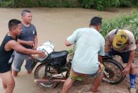 Ket.Foto : Kapolres Way Kanan AKBP Didik Kurnianto,S.I.K. turun kelapangan membantu menyeberangkan warga, di penyeberang Sungai Jungkang, Minggu (15/02/2026) 