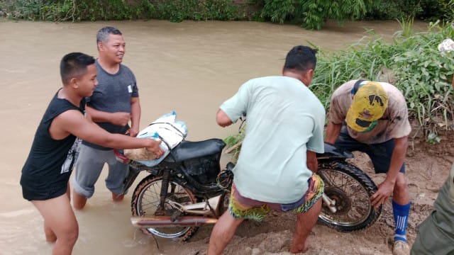 Ket.Foto : Kapolres Way Kanan AKBP Didik Kurnianto,S.I.K. turun kelapangan membantu menyeberangkan warga, di penyeberang Sungai Jungkang, Minggu (15/02/2026) 
