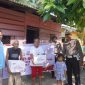 Keterangan foto : Personel Kepolisian membagikan bingkisan sosial kepada masyarakat yang berhak menerimanya.