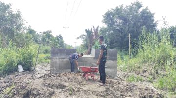 keterangan foto : Personel Koramil 01/Tembilahan bahu-membahu dengan masyarakat menuntaskan penimbunan material di sekitar pondasi angkur, bagian krusial dari pembangunan Jembatan Garuda yang berlokasi di Kelurahan Seberang Tembilahan Barat, Kecamatan Tembilahan, Kabupaten Indragiri Hilir.