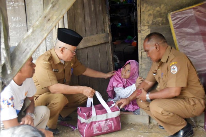 Keterangan Foto: Plh Kepala Dinas Sosial Tapanuli Tengah, Faisal Fahmi Lubis, menyerahkan bantuan sosial kepada penyandang disabilitas warga Lubuk Tukko, Kecamatan Pandan.