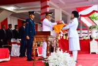 Keterangan Foto: Bupati Tapanuli Tengah, Masinton Pasaribu, menyerahkan Bendera Pusaka kepada Paskibraka Tapanuli Tengah dalam upacara peringatan HUT ke-81 RI di Lapangan GOR Pandan, Senin (17/8/2026).

-