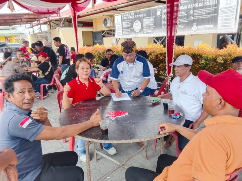 Keterangan Foto: Suasana turnamen Domino Ceria dalam rangka HUT RI ke-81 antara jurnalis, personel Polsek Medan Labuhan, dan masyarakat.