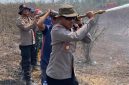 Keterangan Foto: Kapolres Way Kanan AKBP Ramadhona, S.H., S.I.K., saat melakukan penyemprotan air di lokasi titik api kebakaran hutan dan lahan.