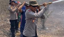 Keterangan Foto: Kapolres Way Kanan AKBP Ramadhona, S.H., S.I.K., saat melakukan penyemprotan air di lokasi titik api kebakaran hutan dan lahan.