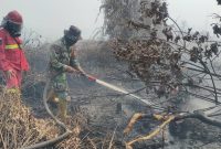 Keterangan Foto: Anggota Koramil 07-0313/KPR bersama unsur Polri, Manggala Agni, dan BPBD melakukan pemadaman dan pendinginan untuk memastikan bara api tidak kembali menyala di lokasi kebakaran.