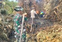 Keterangan Foto: Personel TNI dari Kodim 0314/Indragiri Hilir bersama Yonif TP 953/Harimau Rawa melakukan pendinginan lahan gambut yang terdampak kebakaran di Kelurahan Sungai Beringin, Tembilahan.