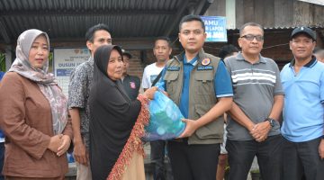 Keterangan foto: Wali Kota Langsa Jeffry Sentana S. Putra, S.E. menyerahkan bantuan kepada warga terdampak banjir, baik secara langsung maupun melalui para geuchik. 