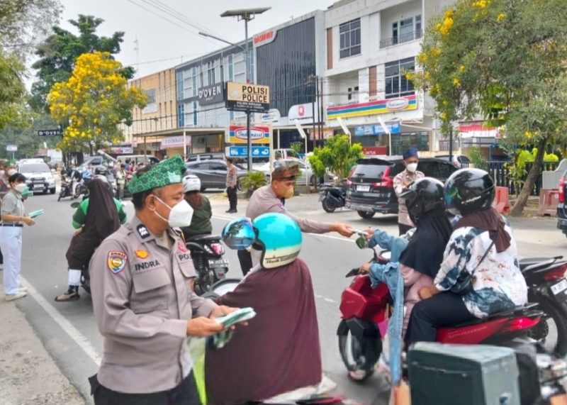 Keterangan foto: Personel Polres Pekanbaru membagikan masker kepada warga, khususnya mereka yang tetap harus beraktivitas di luar ruangan.