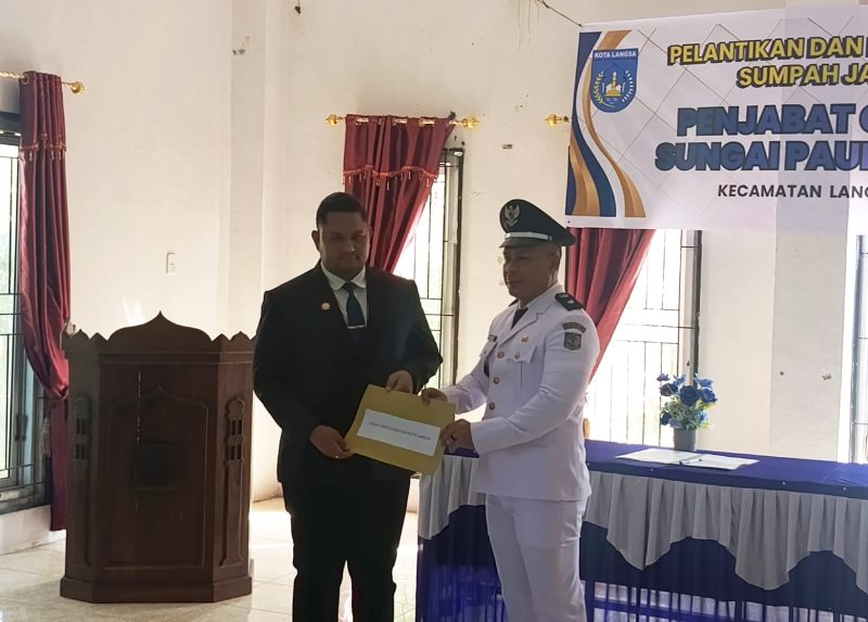 Ket. Foto : Camat Risky Andrian Menyerahkan Surat Keputusan sebagai Pj Geuchik Gampong Sungai Paoh Pusaka, Kepada Saifullah, M.Pd