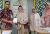 Ket. Foto : Petugas BPBD Langsa menyerahkan bantuan kepada korban banjir di Bank BSI Cabang Langsa.