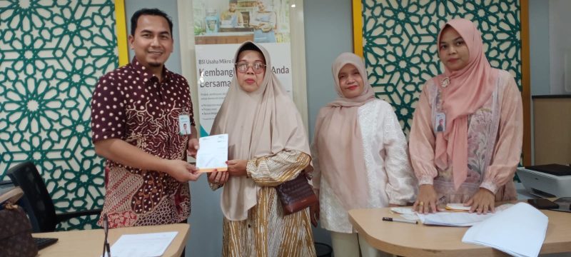 Ket. Foto : Petugas BPBD Langsa menyerahkan bantuan kepada korban banjir di Bank BSI Cabang Langsa.