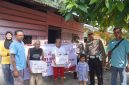 Keterangan foto : Personel Kepolisian membagikan bingkisan sosial kepada masyarakat yang berhak menerimanya.
