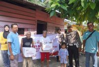 Keterangan foto : Personel Kepolisian membagikan bingkisan sosial kepada masyarakat yang berhak menerimanya.
