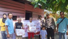 Keterangan foto : Personel Kepolisian membagikan bingkisan sosial kepada masyarakat yang berhak menerimanya.