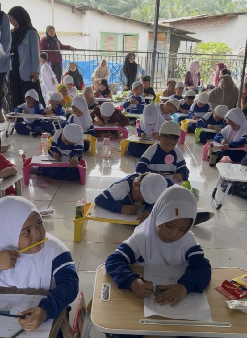 Keterangan foto: Mahasiswa KKN Kelompok 06 sebagai penanggung jawab cabang mewarnai untuk anak-anak usia dini di Desa Tanjung Putus.