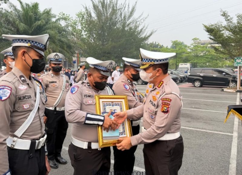 Keterangan foto : Dirlantas Polda Riau Kombes Pol Jeki Rahmat Mustika, S.I.K., M.H.,  memberikan penghargaan Kepada personil Lantas yang berprestasi, Kamis (17/9/2026) 
