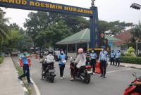 Keterangan foto : Personil TNI AU, membagikan Masker kepada masyarakat yang lewat di Jl. Adi Sucipto