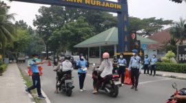 Keterangan foto : Personil TNI AU, membagikan Masker kepada masyarakat yang lewat di Jl. Adi Sucipto