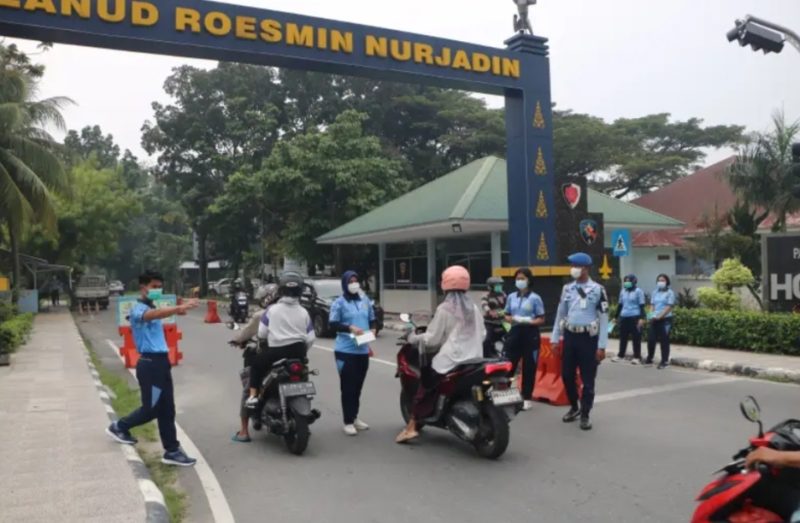 Keterangan foto : Personil TNI AU, membagikan Masker kepada masyarakat yang lewat di Jl. Adi Sucipto